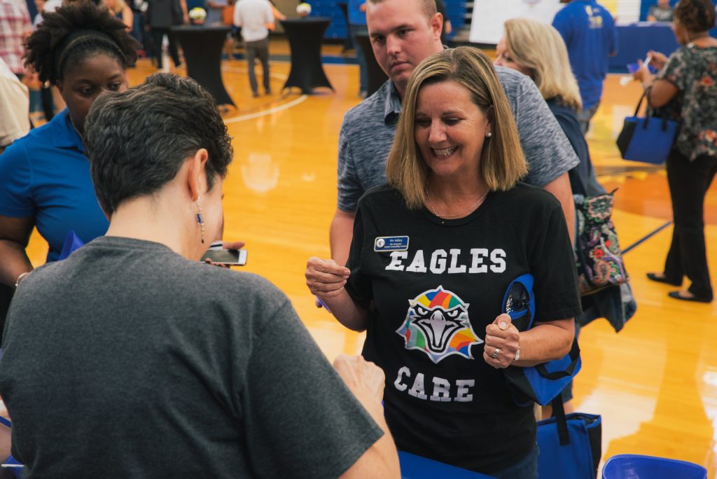 A staff member with an "Eagles Care" t-shirt on at the TCC Eagles RISE 2018 ice cream social