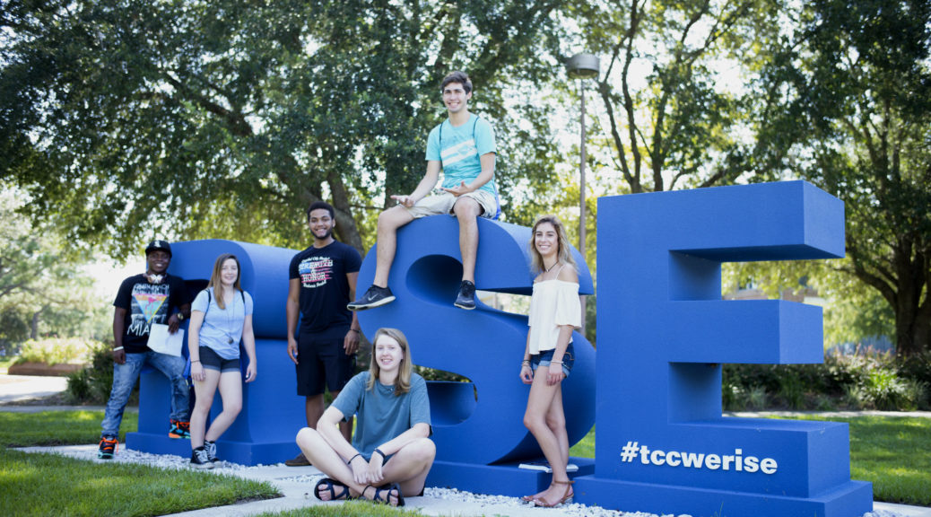 Students near the "RISE" sign on campus